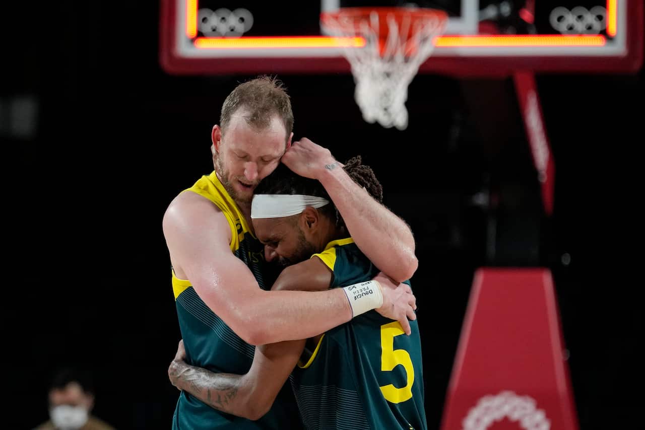 Australia's Joe Ingles (7) and Patty Mills (5) react after beating Slovenia 107-93 during the men's bronze medal basketball game at the 2020 Summer Olympics.