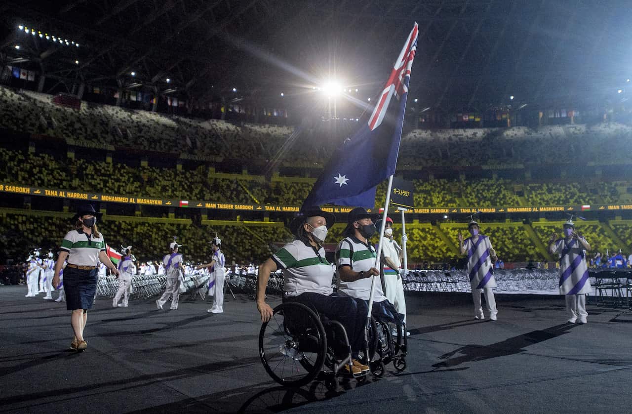 Co-Captains of the Australian Paralympic Team in Tokyo, Danni Di Toro and Ryley Batt, carry the flag at the Opening Ceremony