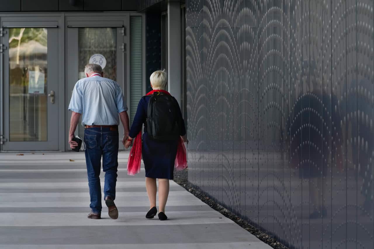 Two people hold hands as they walk to the court in the trial of four men charged with murder over the downing of Malaysia Airlines flight MH17.
