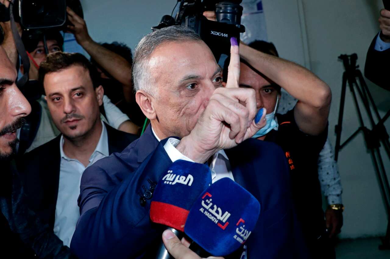 Iraqi Prime Minister Mustafa al-Kadhimi displays his ink-stained finger at a polling centre during the parliamentary elections in Baghdad, Iraq.