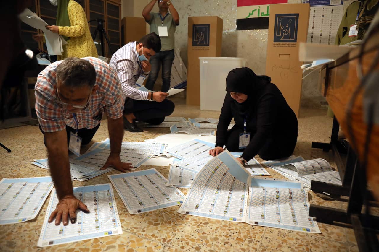 Iraqi election committee staff members count the votes at the end of the parliamentary election day at a polling station in Baghdad's Karada district.