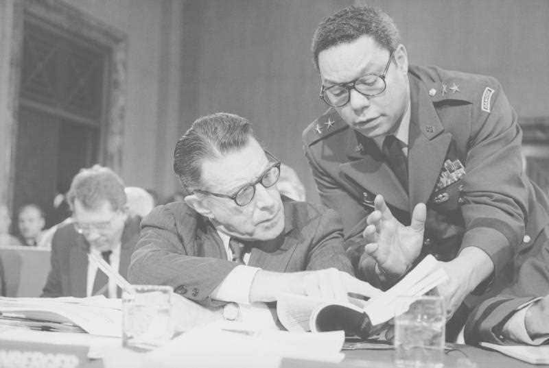Then-Defense Secretary Casper Weinberger with Colin Powell during testimony before the Senate in 1985