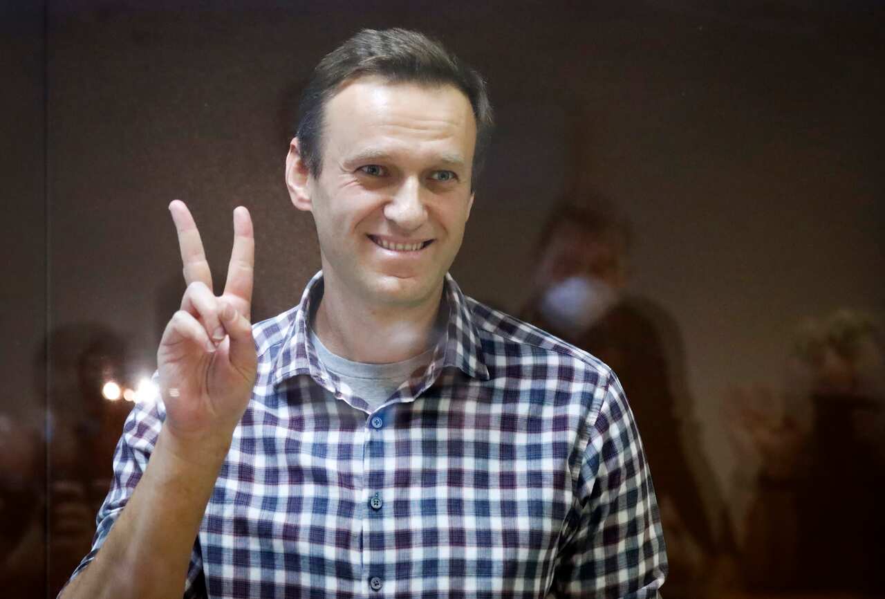 Russian opposition leader Alexei Navalny stands in a cage in the Babuskinsky District Court in Moscow, Russia, Saturday, Feb. 20, 2021