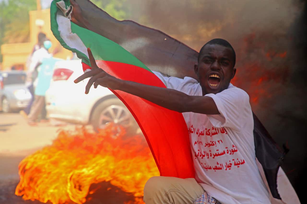 A protester holds a Sudanese flag during demonstrations in support of the civilian government in Khartoum, Sudan, 21 October 2021