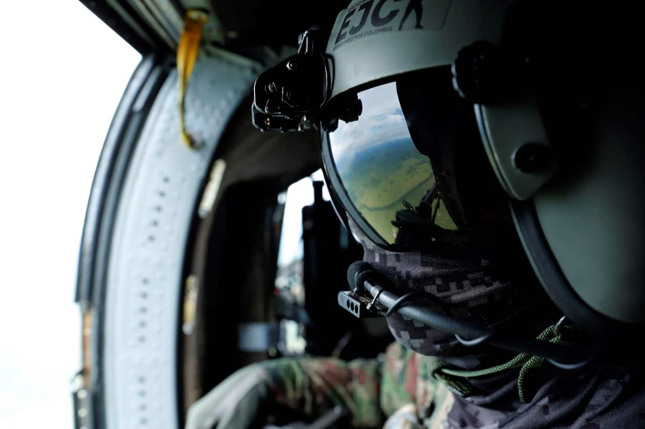 A soldier aboard a helicopter participates in a security operation in Carepa, Colombia, 24 October 2021.