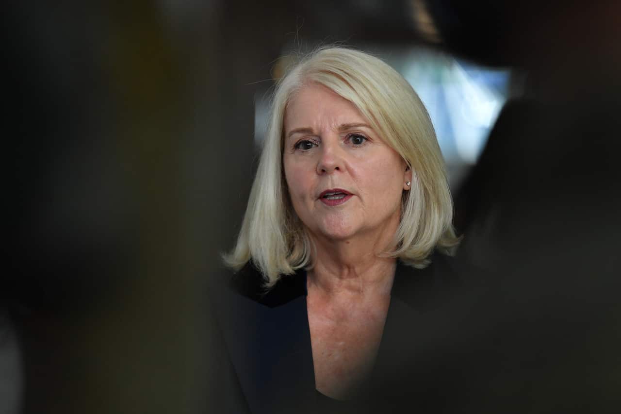 Blonde woman in a dark blazer.