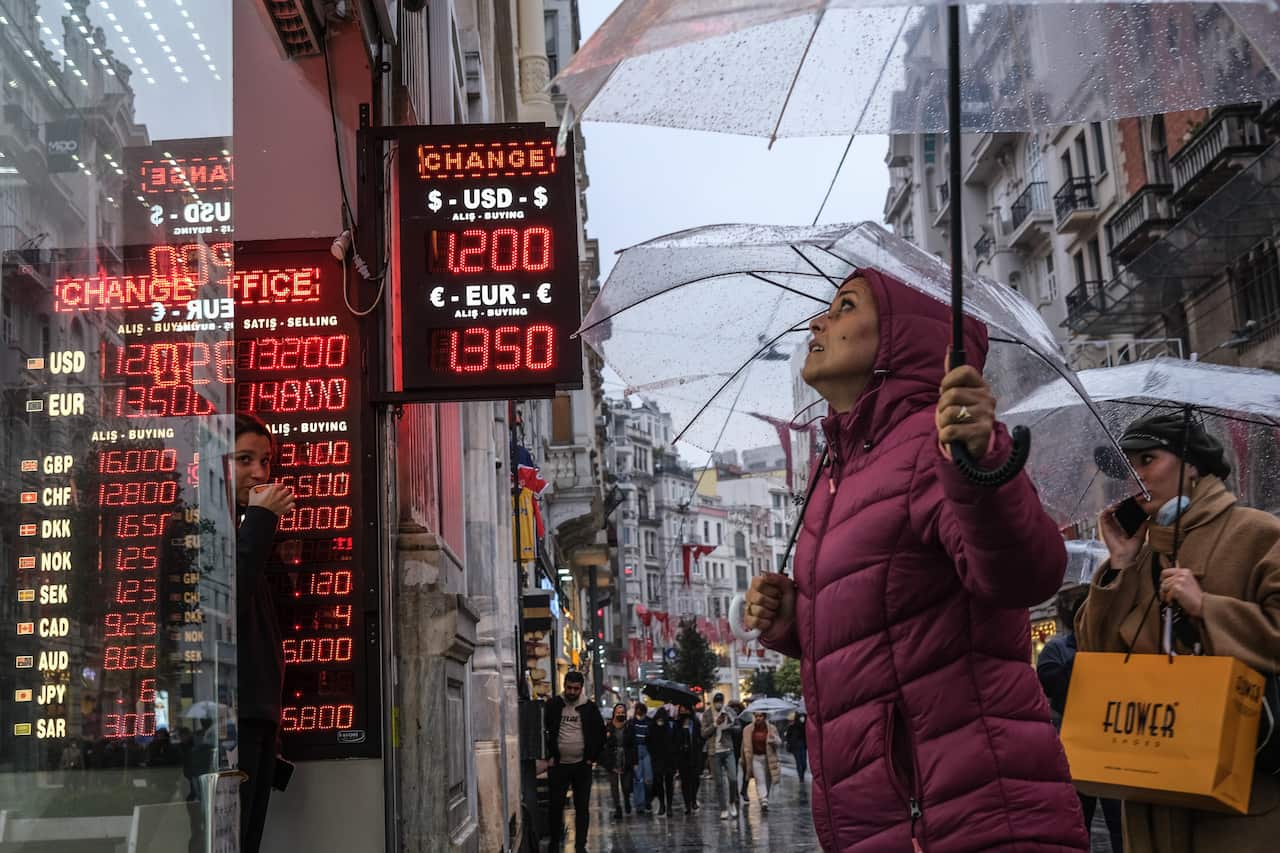 People check rates on a board of currency exchange office in Istanbul, Turkey, 23 November 2021.