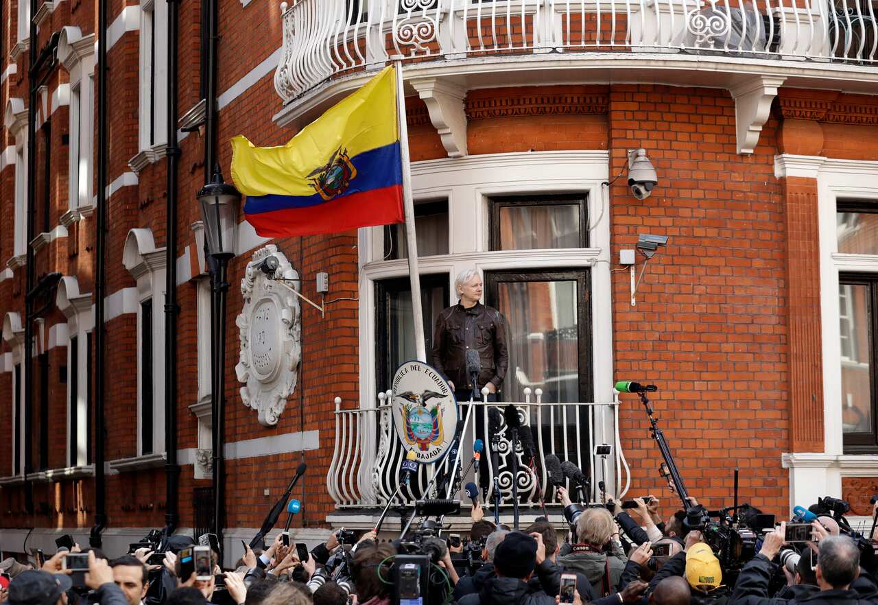 Julian Assange gestures on the balcony of the Ecuadorian embassy