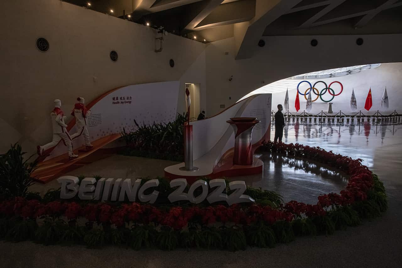 A security guard stands by the Olympic logo