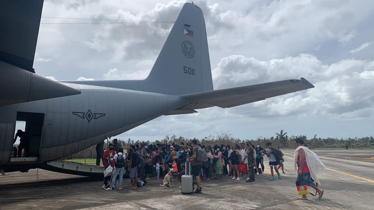 esidents and tourists affected by Typhoon Rai, boarding a C-130 military cargo plane in Siargao island,  