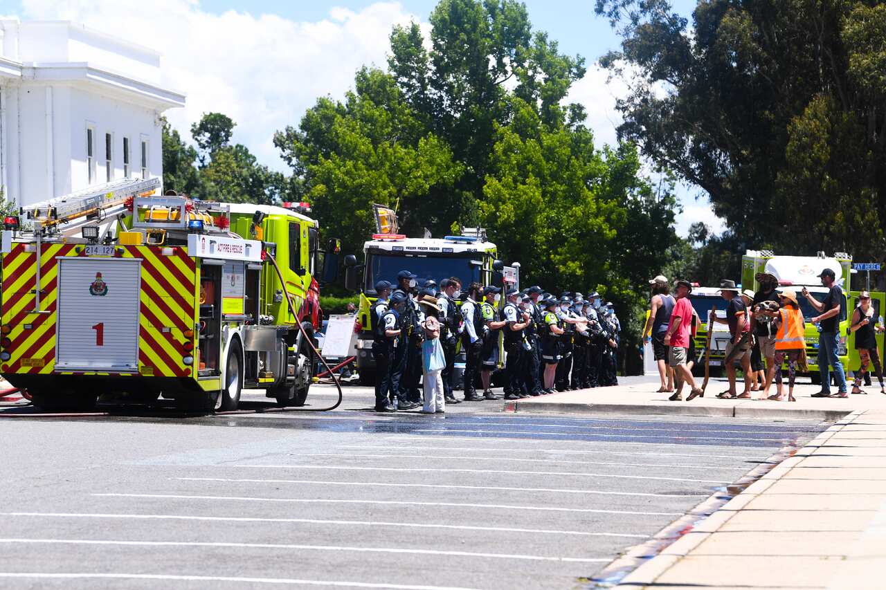Protesters stood in front of a line of Police officers guarding Old Parliament House