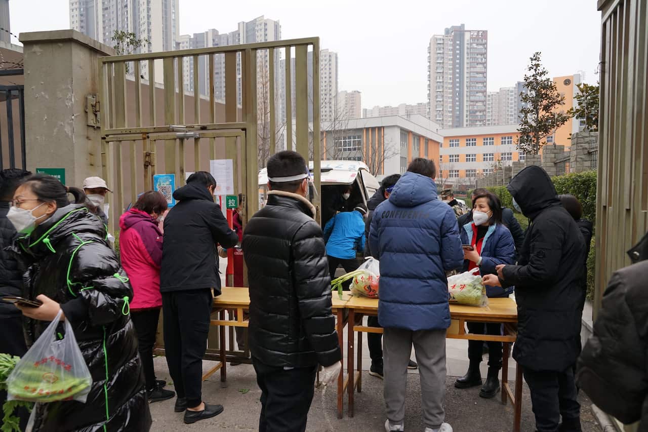 Residents line up to buy vegetables in a gated community in Xi 'an, Shaanxi Province, China, on 31 December, 2021. 