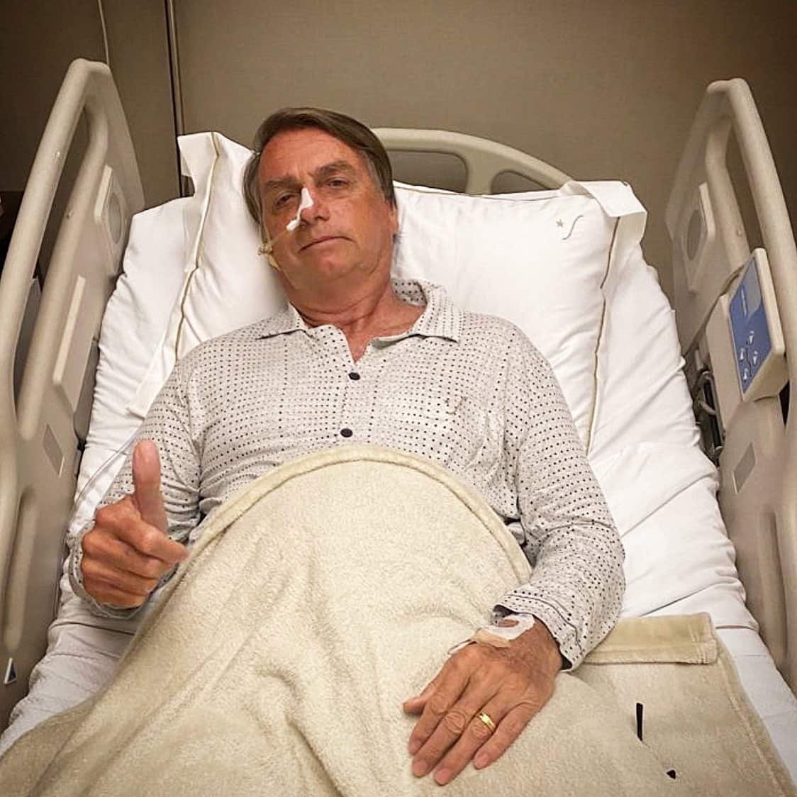 An image taken from Brazilian President Jair Bolsonaro's official Twitter feed showing him giving the thumbs-up from his hospital bed