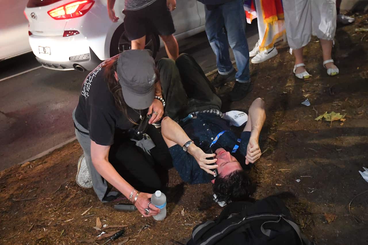 A member of the press (right) is seen on the ground after sustaining an injury during the protest.