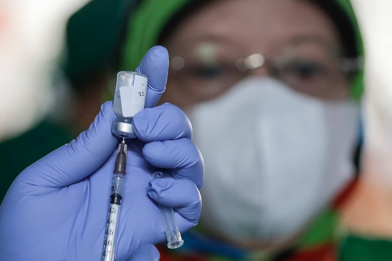 A healthcare worker prepares a dose of the Covid-19 booster vaccine 
