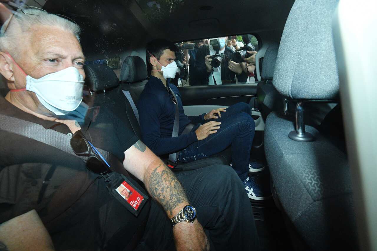 Serbian tennis player Novak Djokovic (centre) departs from the Park Hotel government detention facility, Sunday, January 16, 2022. 
