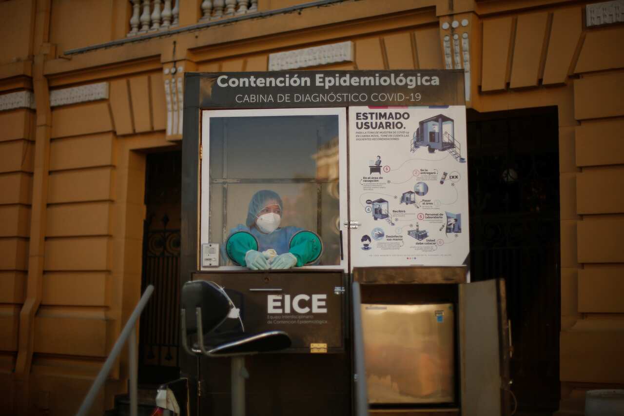 A health worker works in a test booth to detect COVID-19 in Plaza Morazan, in San Salvador, El Salvador. 
