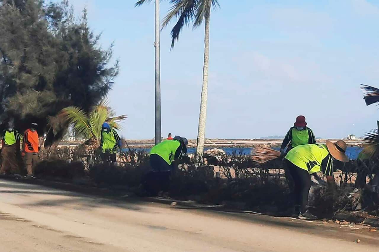 People clear debris off the street in Nuku'alofa, Tonga, following the volcanic eruption near the Pacific archipelago. 