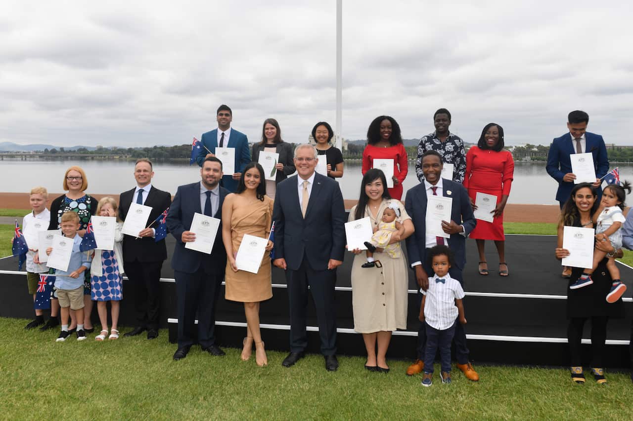 Prime Minister Scott Morrison poses with new citizens during the National Australia Day Flag Raising and Citizenship Ceremony in  Canberra, Wednesday, January 26, 2022. (AAP Image/Mick Tsikas) NO ARCHIVING