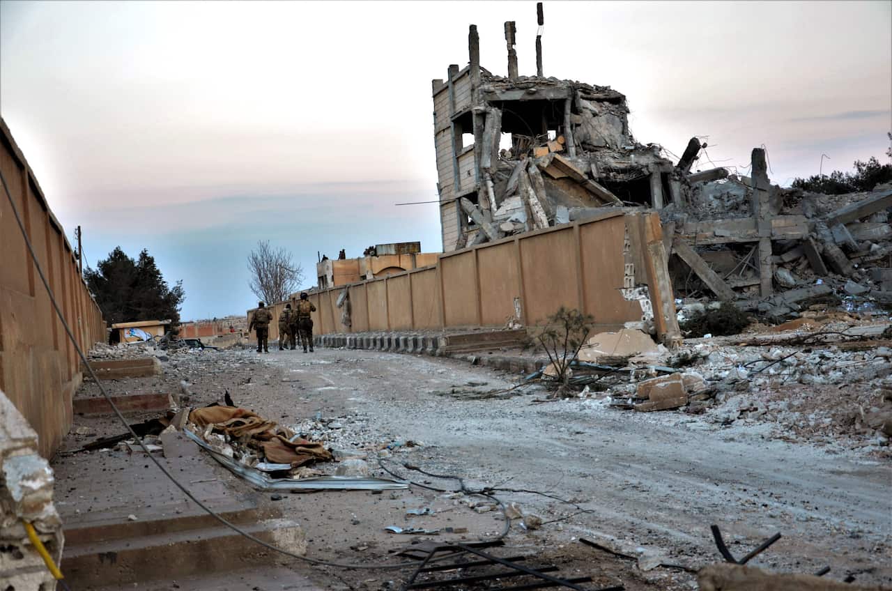 epaselect epa09710706 Fighters of Syria Democratic Forces (SDF) walk amid damage of Ghwayran prison in Hassakeh, northeastern Syria, 26 January 2022. The US-backed Syria Democratic Forces (SDF) on 26 January announced they had recaptured Ghwayran prison i