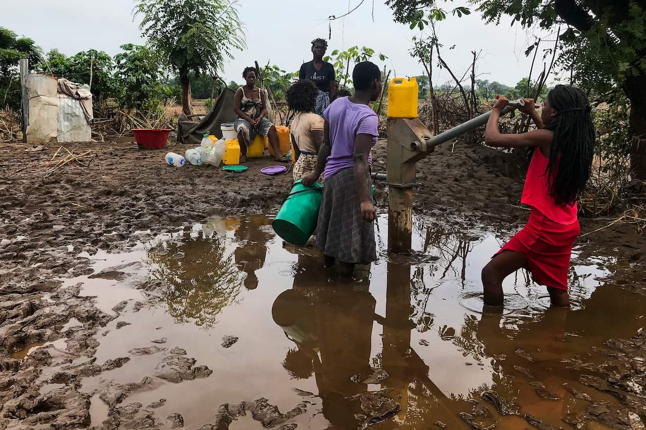 Women take water from a well to start cleaning their homes after Tropical Storm Ana hit the district of Tete, Mozambique.