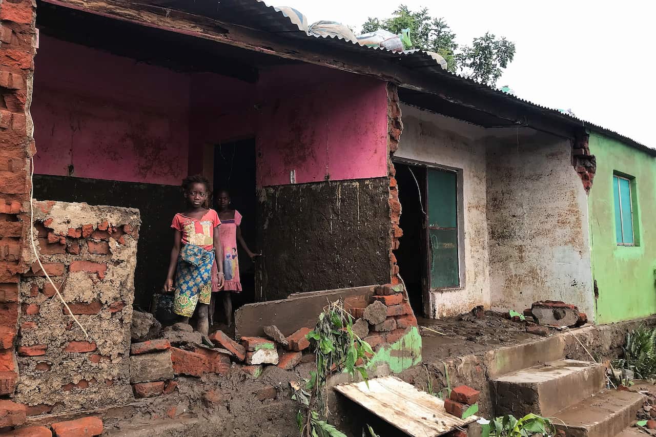 Children stand at their destroyed house after Tropical Storm Ana hit the district of Tete, Mozambique.