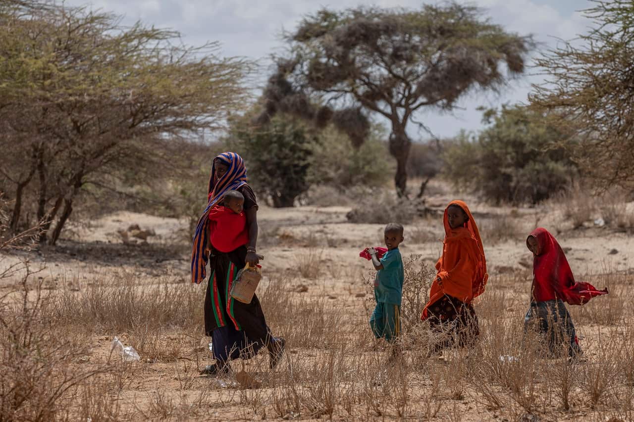 A woman and her children cross a dry field as they go in search of water, near Sagalo village in the Somali region of Ethiopia Thursday, Jan. 20, 2022