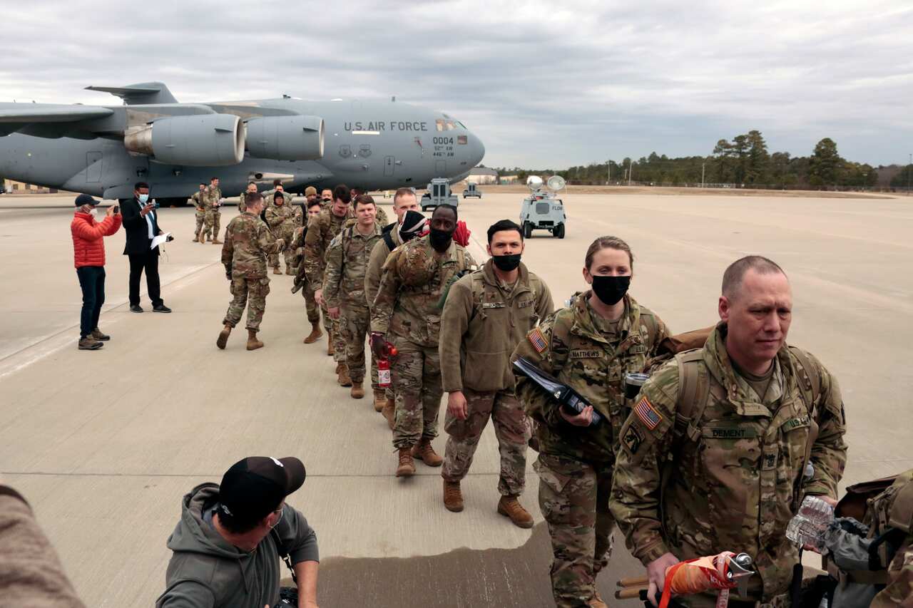 U.S. Army soldiers from the 18th Airborne Division board a C-17 aircraft as they deploy to Europe,