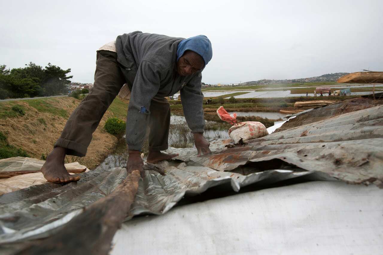 A man secures the roof of his home his during bad weather in Madagascar, Saturday, 5 February, 2022. 