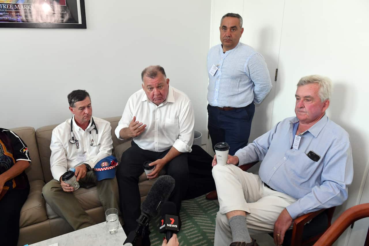 A man sits beside protestors. 