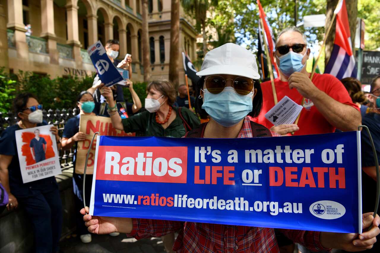 Nurses hold placards during a nurses’ strike outside the NSW Parliament House in Sydney, Tuesday, February 15, 2022. NSW public hospital nurses are on strike over understaffing frustrations, pay and conditions. (AAP Image/Bianca De Marchi) NO ARCHIVING