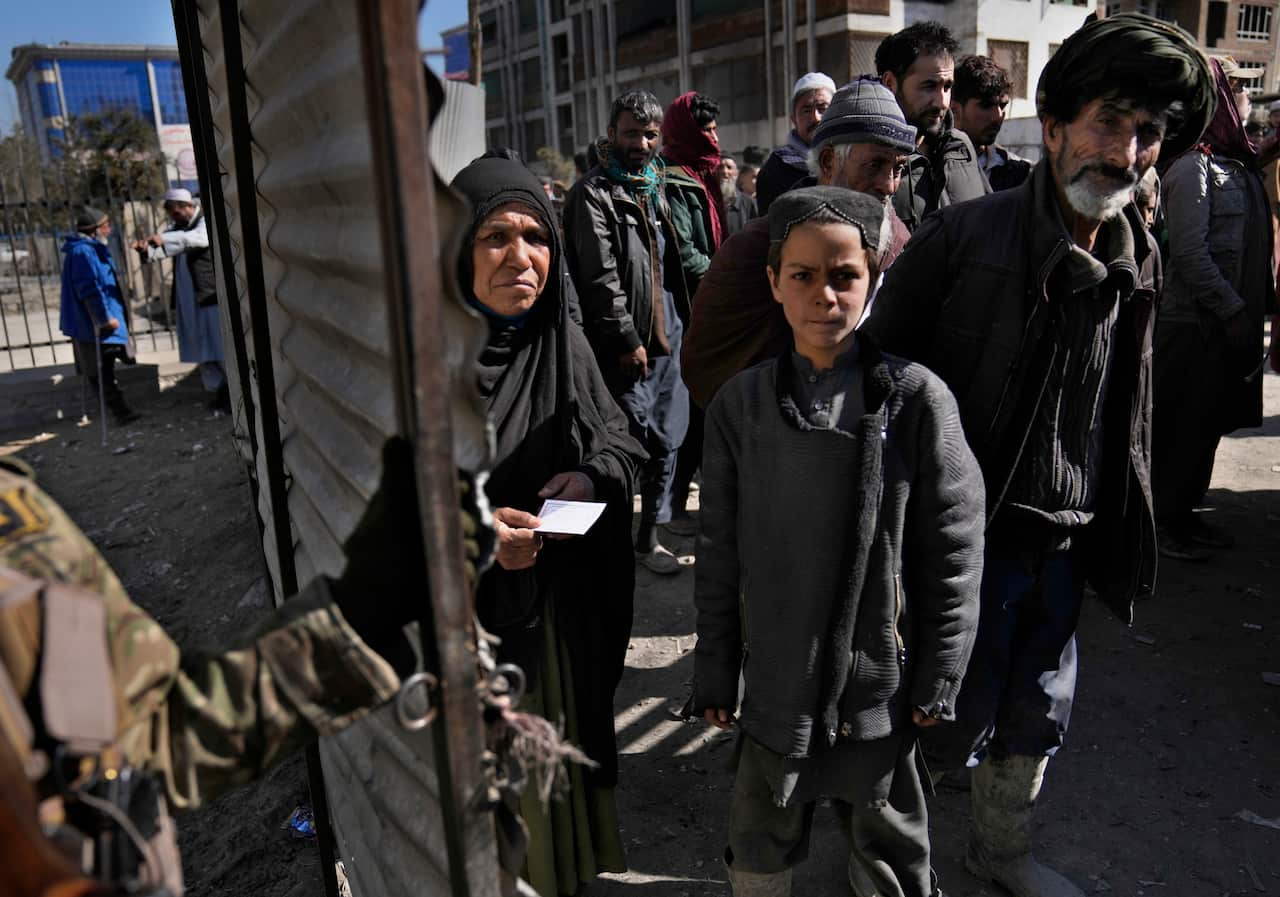 Afghan people waiting to receive food supplies, during a humanitarian aid campaign for the poor families, in Kabul, Afghanistan.