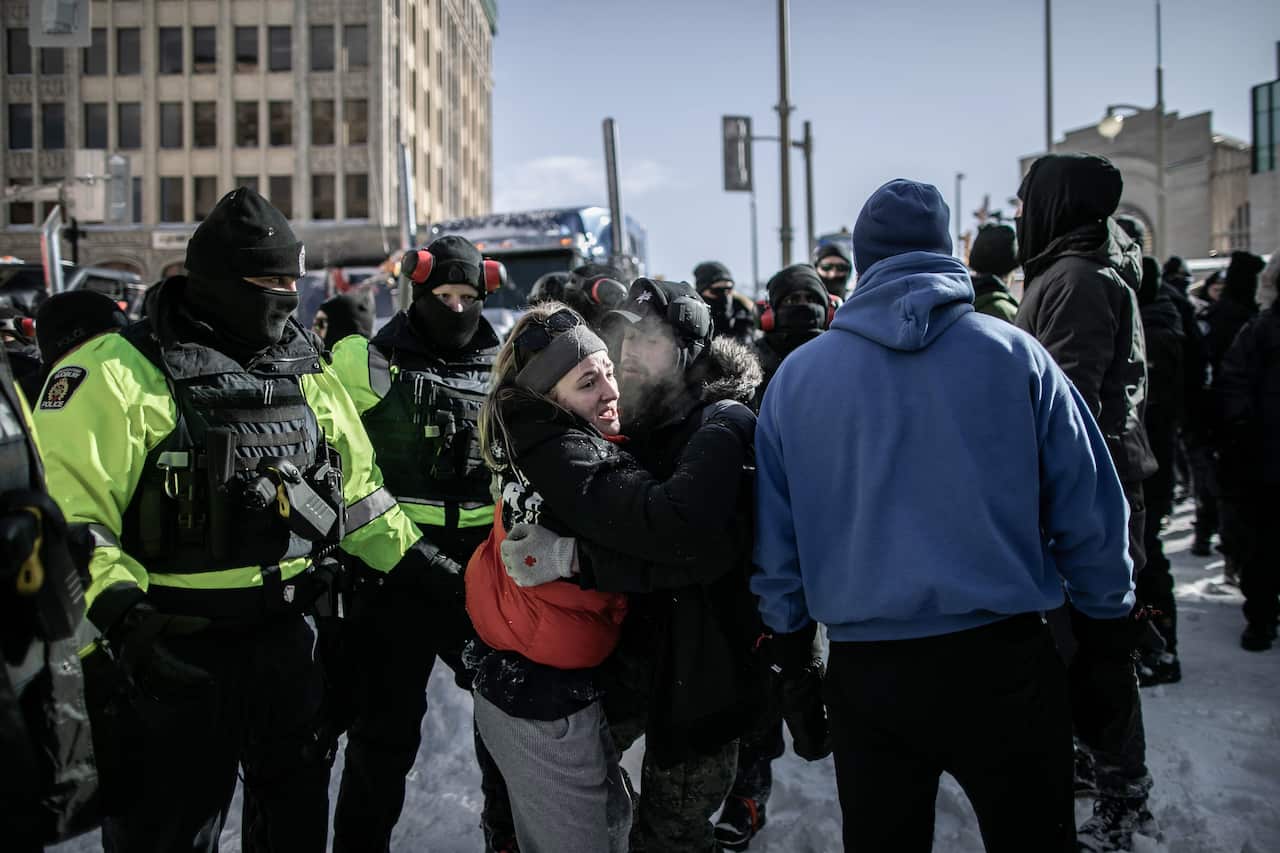 Police are seen in the city center as they clear a protest by Canadian truck drivers over COVID-19 restrictions has led to gridlock.