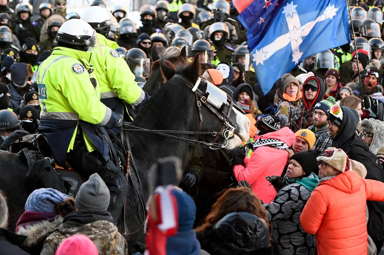 Protesters react as Toronto Police mounted unit charge to disperse as police take action to put an end to a protest.