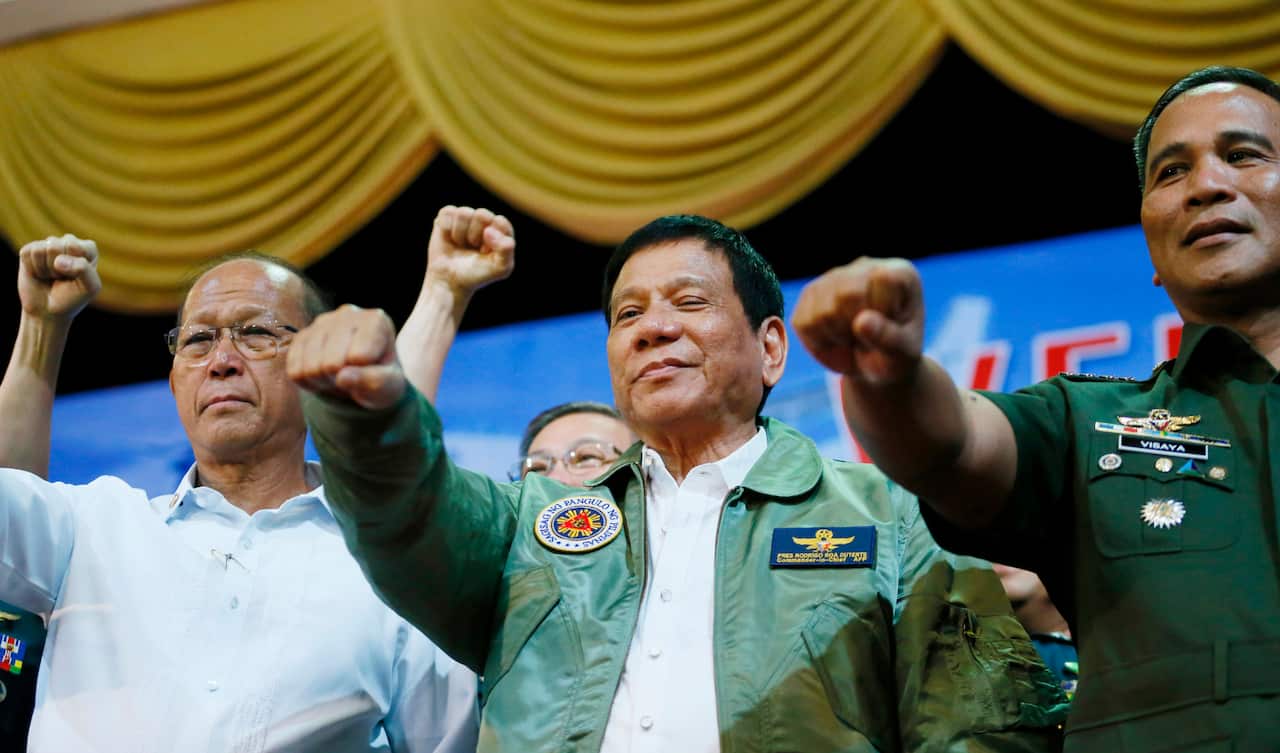 President Rodrigo Duterte, center, poses with a fist bump with Defense Chief Delfin Lorenzana, left, and Armed Forces Chief Ricardo Visaya (AP Photo).
