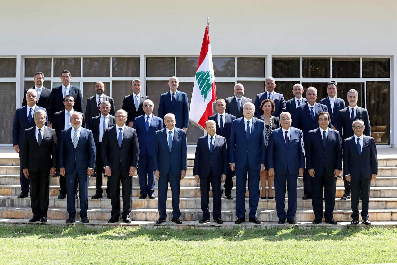 In this photo released by Lebanese government, members of the new government pose for an official picture at the Presidential Palace.