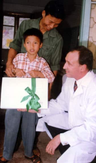 Prime Minister Paul Keating receives a gift from a successfully treated patient, Tran Van Giap, while visiting Vietnam in 1994.