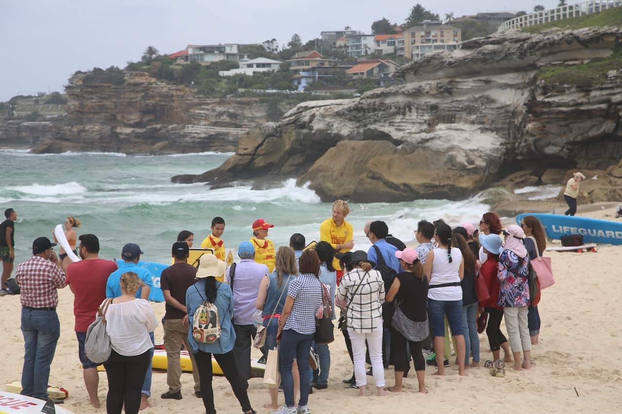 Migrants and refugees take part in the workshop at Tamarama beach.