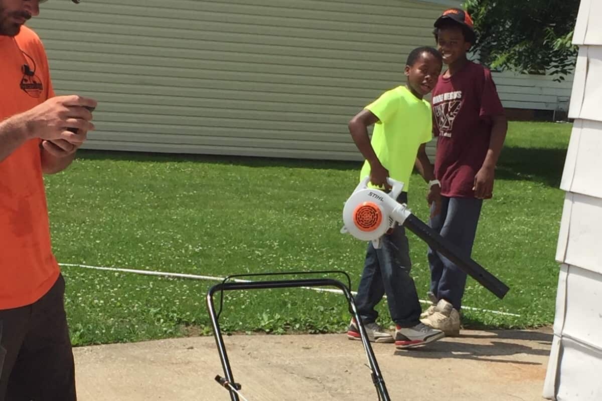 Reginald Fields holding a leaf blower.