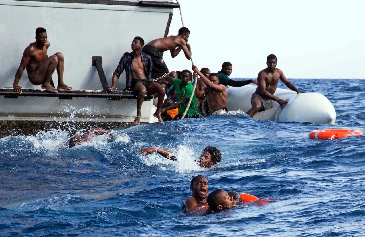 Migrants whose dinghy was sinking tried to board a Libyan coast guard ship during a rescue operation off the coast of Libya in November.