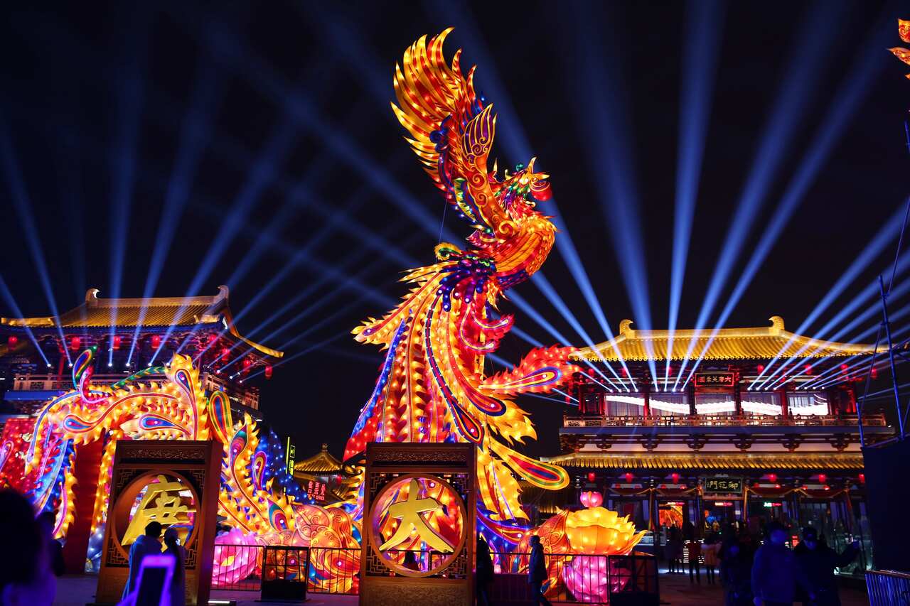 A colored lantern featuring a phoenix is illuminated during a lantern show.