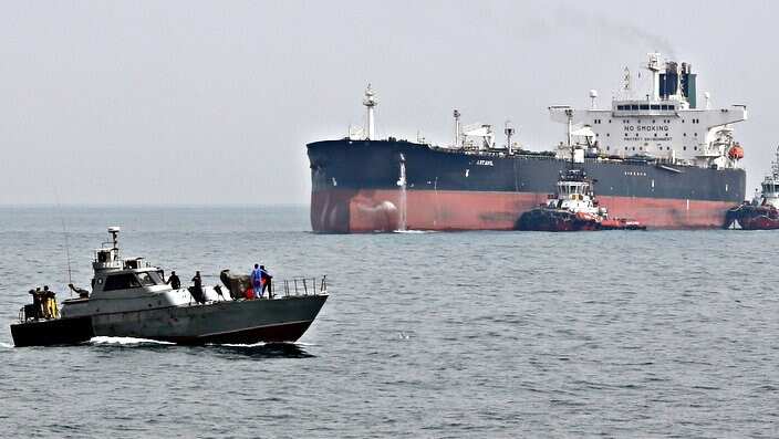 An Iranian military boat patrols next to the Artavil oil tanker in the Persian Gulf.