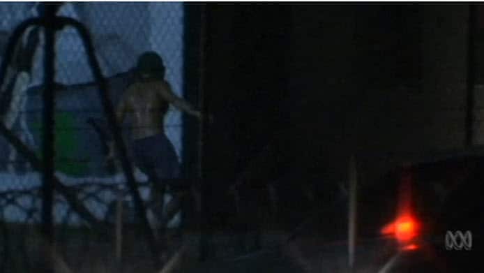 A teenager at Don Dale is seen through the fence.