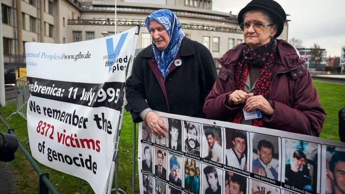 Demonstrators hold banners outside the Yugoslav War Crimes Tribunal.