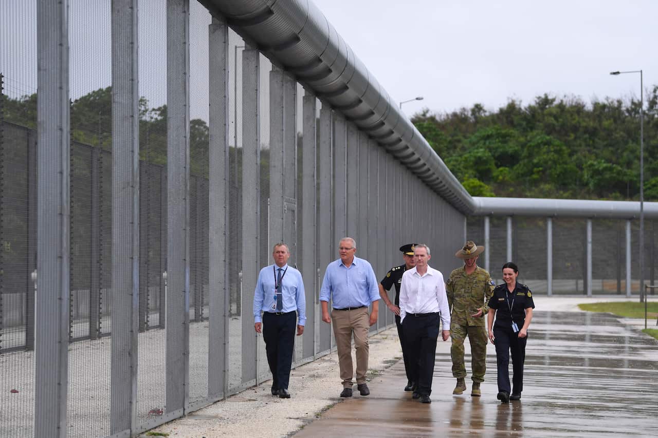 Australian Prime Minister Scott Morrison is seen near the perimeter fence as he tours North West Point Detention Centre on Christmas Island