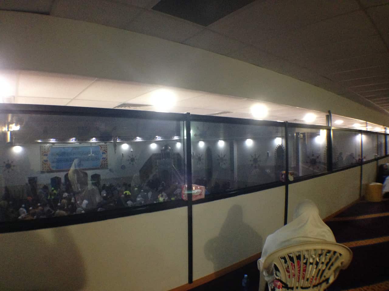 Men sit below and listen to ancient prayers. (SBS)