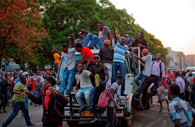 Zimbabweans celebrate outside the parliament building immediately after hearing the news that President Robert Mugabe had resigned.