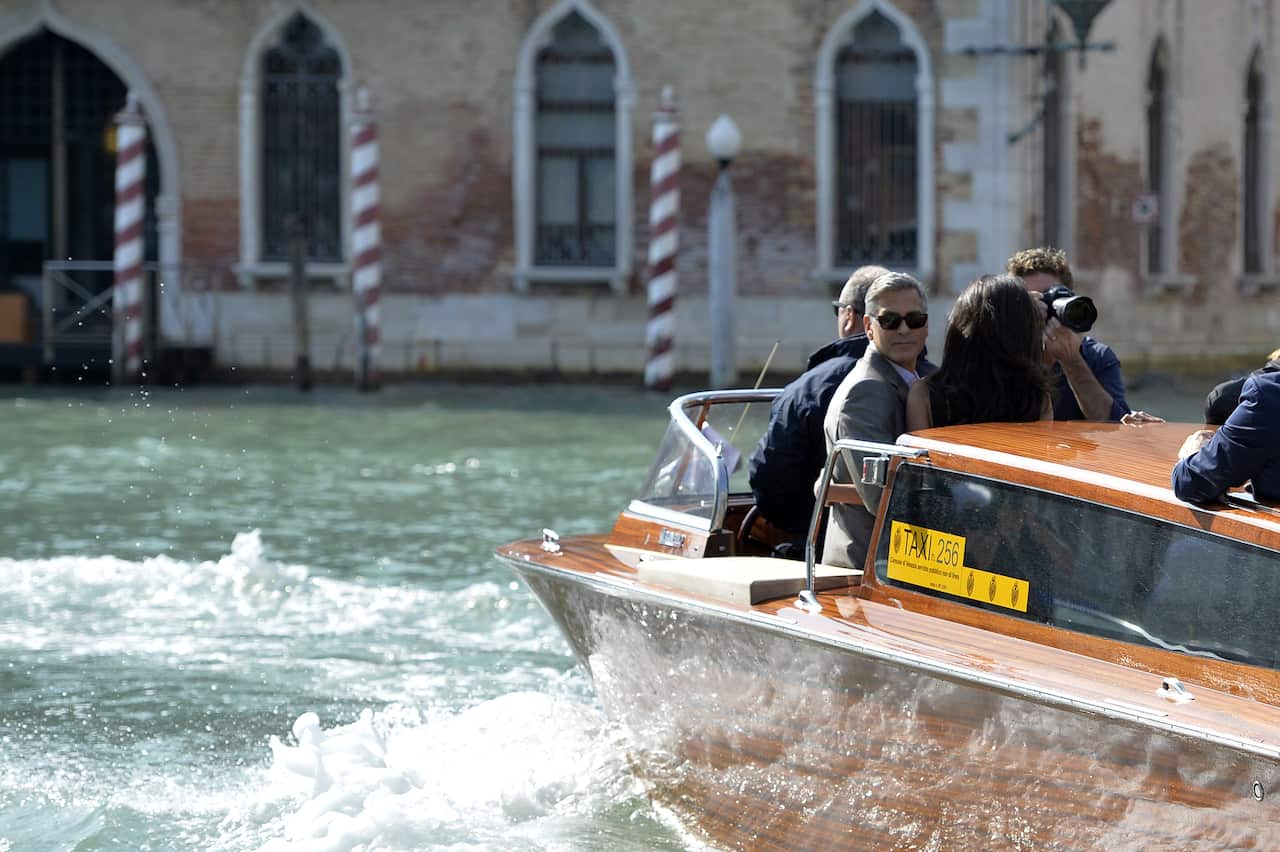 George Clooney and his Lebanon-born British fiancee Amal Alamuddin take a taxi boat upon their arrival in Venice. (Getty)