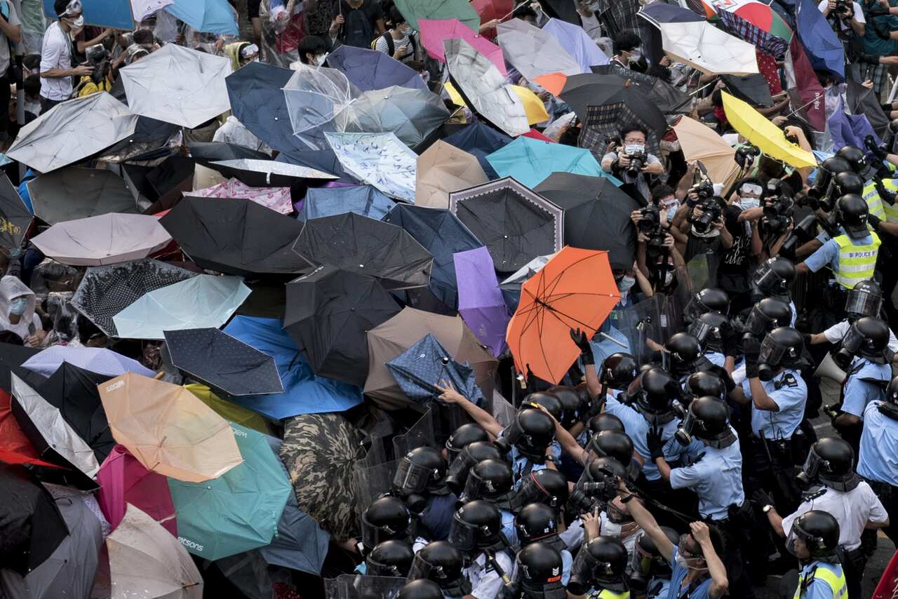 Hong Kong Pro-democracy protesters use umbrellas to shield themselves from pepper spray