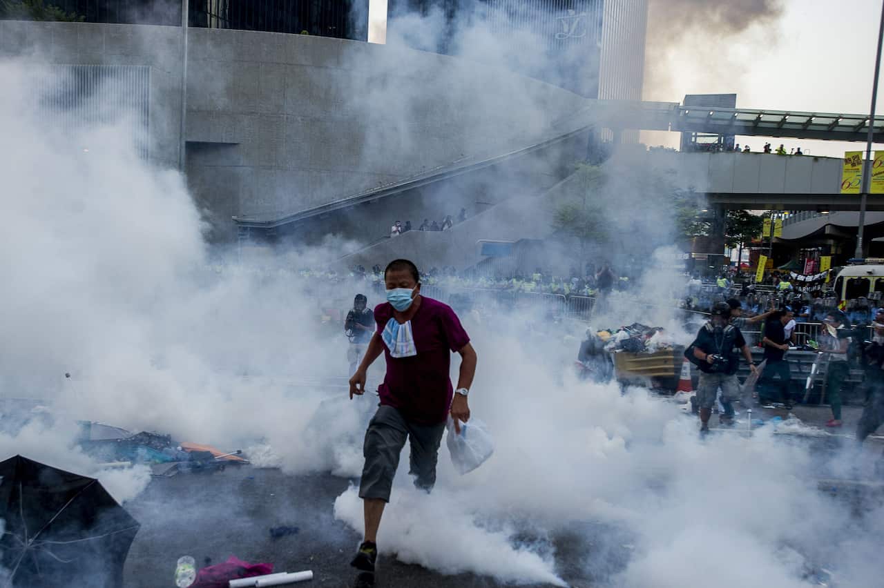 A pro-democracy demonstrator runs through a cloud of tear gas towards protesters near the Hong Kong government headquarters.